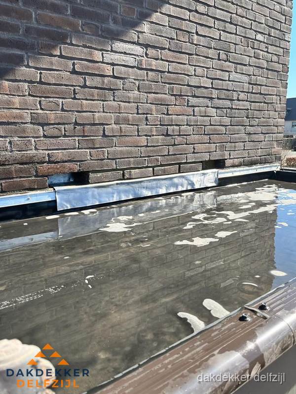 Stilstaand water op plat dak door slechte afwatering in Delfzijl Stilstaand water op plat dak door slechte afwatering in Delfzijl